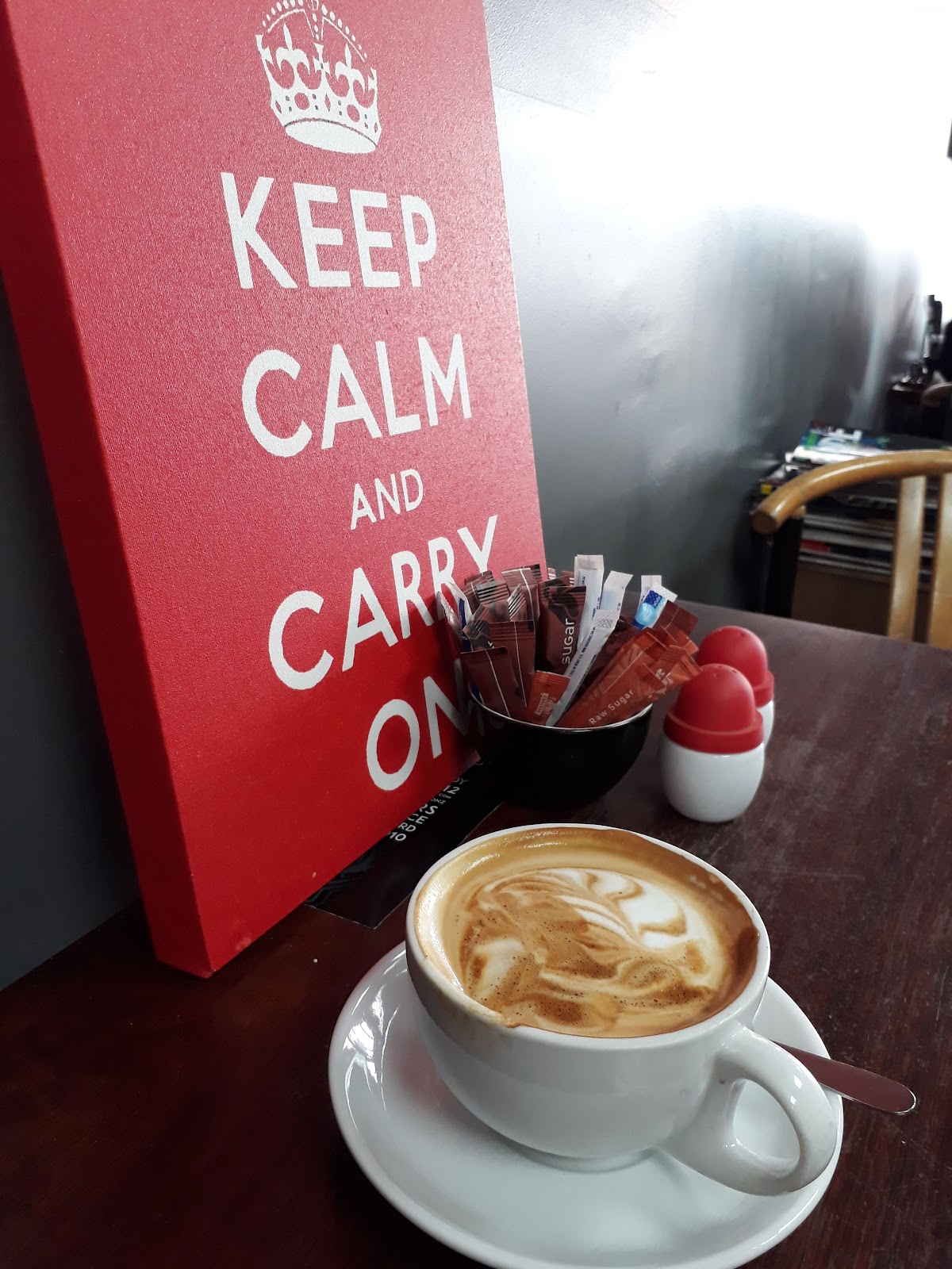 Coffee beside a Keep Calm and Carry On canvas
